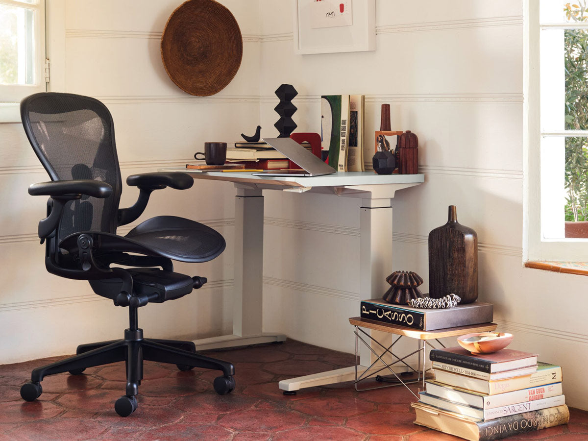 Hemmakontor med Aeron kontorsstol i onyx svart framför kompakt sit-stand-skrivbord