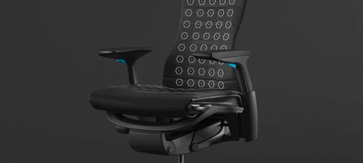 Framifrånvy av en svart och blå Embody-spelstol från Herman Miller, överlagrad med vit grafik som framhäver sitsen och ryggstödet.