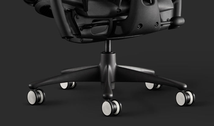 Närbild av en svart Embody-spelstol från Herman Miller, som visar de svarta och vita hjulen.