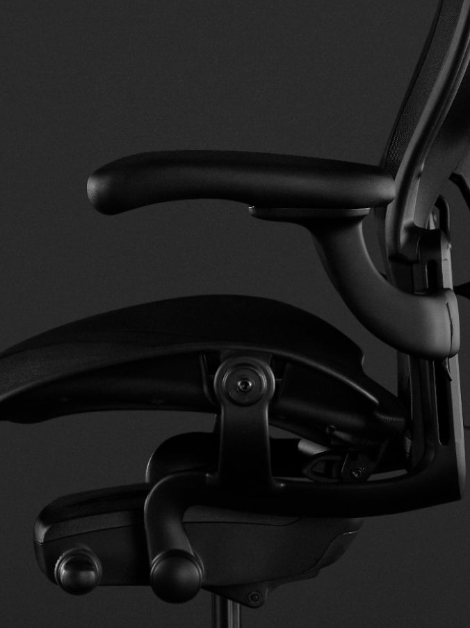 Sidovy av en svart Aeron-spelstol från Herman Miller, som visar de helt justerbara armstöden.