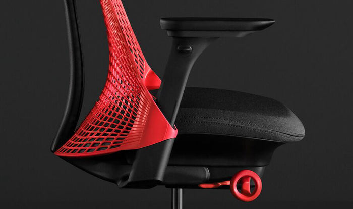 Närbild från sidan av en röd och svart Sayl-gamingstol från Herman Miller, som visar den konturerade sittdynan.