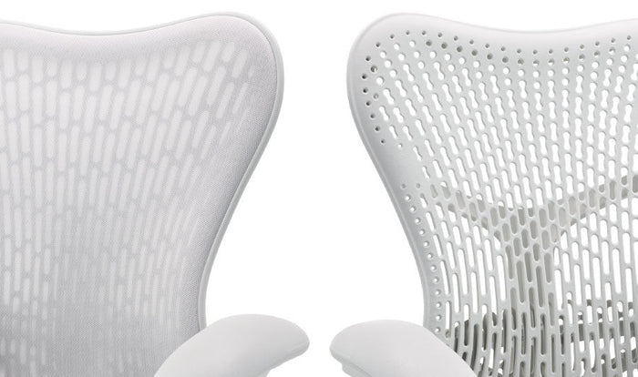 Två vita Mirra 2-kontorsstolar från Herman Miller, placerade bredvid varandra. Visar de två ryggstödsalternativen, ett med ett extra lager tyg och ett utan.