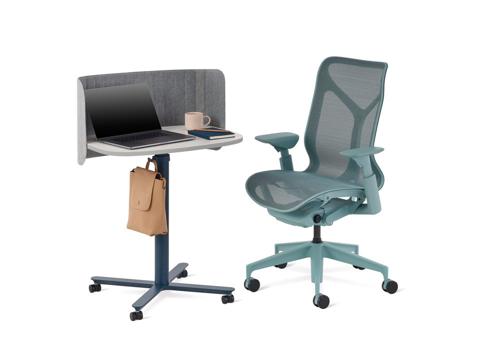 En blå Cosm-kontorsstol från Herman Miller placerad bredvid ett blått och vitt Passport-bord från Herman Miller.