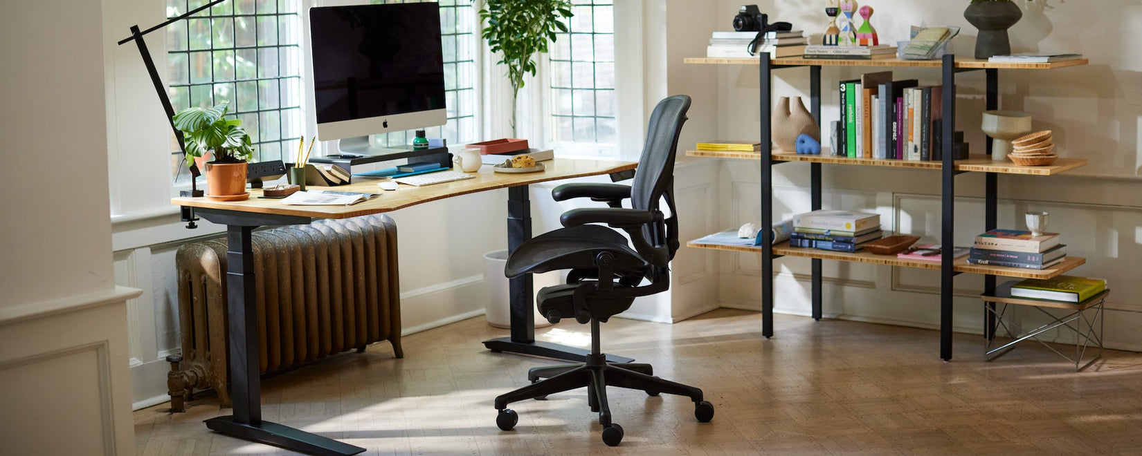 Hemmakontor med ikonisk Herman Miller Aeron-stol i onyx svart med sit-stand Jarvis-skrivbord med ben och konturerad bambu-skiva.