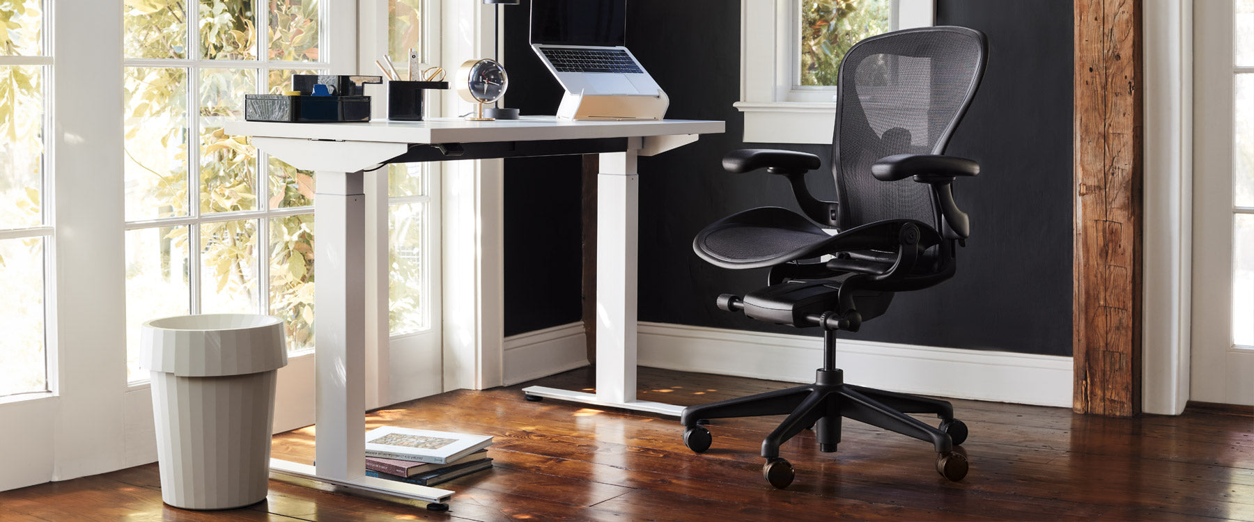 Hemmakontor med Nevi sit-stand-skrivbord i vitt med Aeron kontorsstol i onyx svart, kompletterat med Oripura laptopstativ och Hay Shade papperskorg i benvit