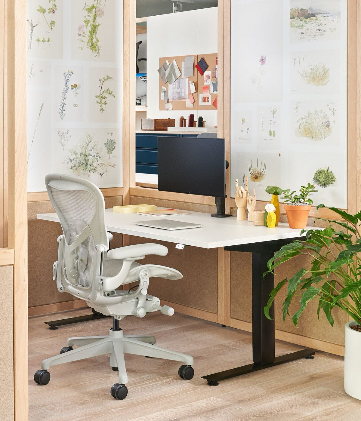 Hemmakontor med Aeron kontorsstol i mineralvit med sit-stand Nevi skrivbord med svarta ben och vit skiva.