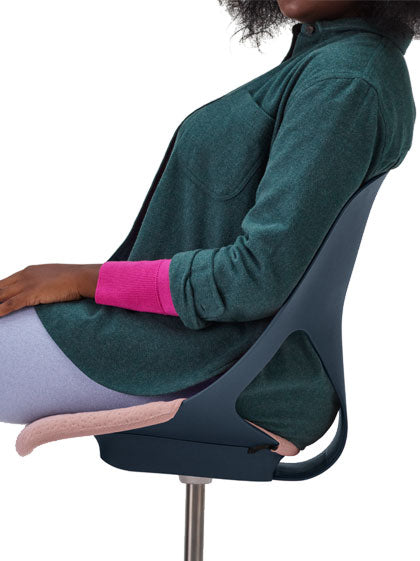 Sidovy av en person som sitter i en blå Zeph-kontorsstol från Herman Miller med rosa sittdyna.