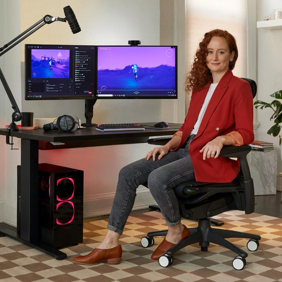 Esportsläkaren Lindsey Migliore framför en speluppsättning med dubbla skärmar på Ollin-skärmarms
