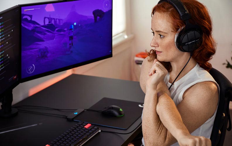 Esports-läkaren Lindsey Migliore framför en speluppsättning med dubbla skärmar på Ollin-monitorarmar.