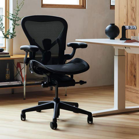 Aeron kontorsstol i grafit i hemmakontor med Nevi sit-stand-skrivbord med vita ben och skiva