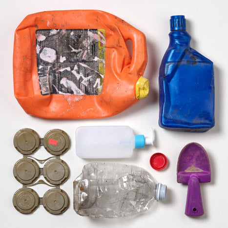 Foto av olika plastföremål som återvunnits från världens hav, inklusive flaskor och lock