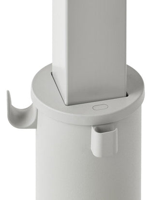 Närbild på ett grått OE1-stående skrivbord från Herman Miller, som visar väskkroken och kabelhållaren.