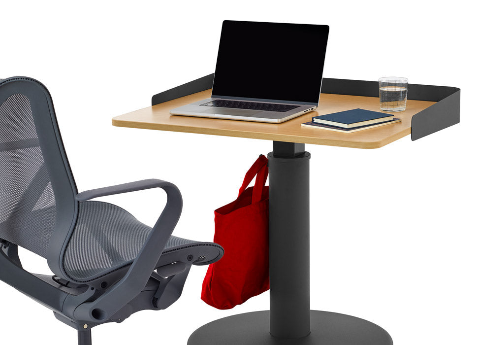 En blå Cosm-kontorsstol från Herman Miller, placerad framför ett svart och askfärgat OE1-stående skrivbord från Herman Miller, med en valfri omslutande skärm.
