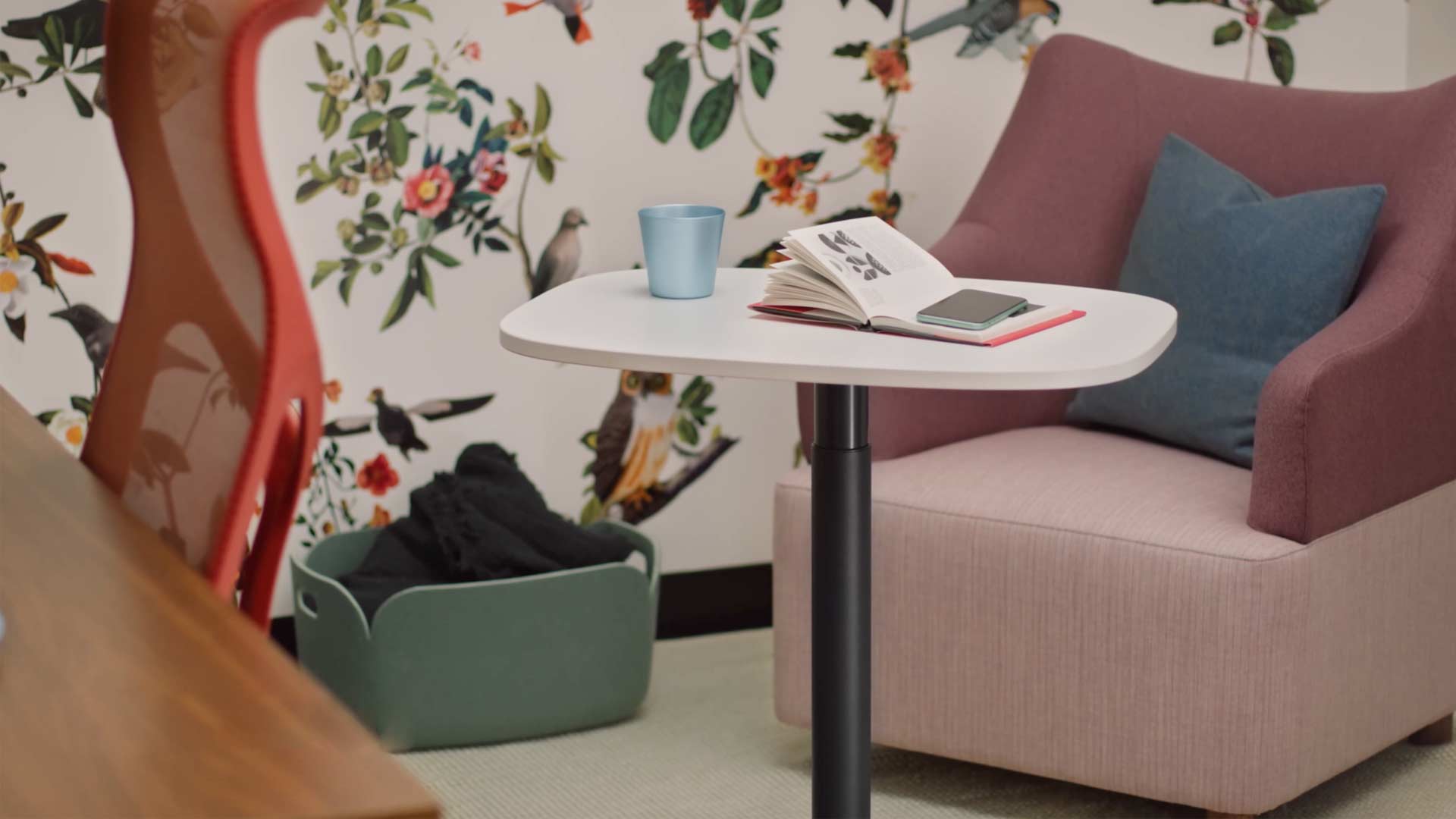 En video av en kvinna som sitter i en gul Wilkes-fåtölj och använder ett Passport-bord från Herman Miller. Videon fortsätter med att visa Passport-bordet i användning på ett antal platser, både på kontor och i hemmiljöer.