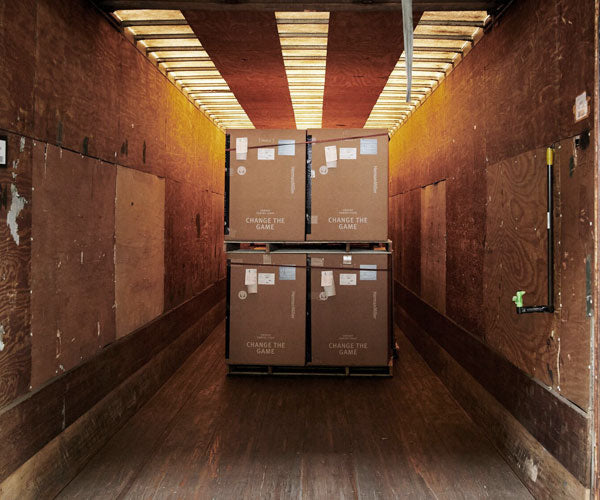 Foto av transporttestet som visar lådor med förpackade stolar i en fraktcontainer. Lådorna tappas för att simulera fraktprocessen och säkerställa att alla Herman Miller-stolar anländer i perfekt skick.