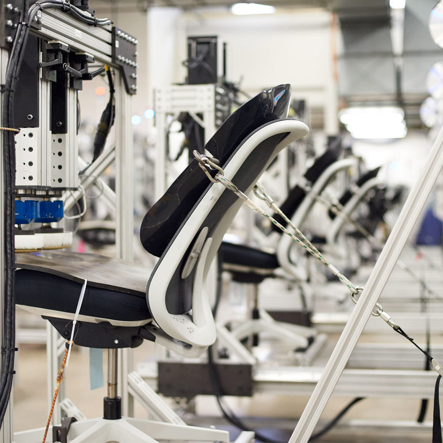 Foto av en Herman Miller-stol som testas för hållbarhet i Herman Millers testlaboratorium