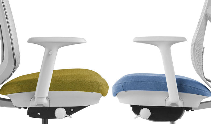 Sidovy av två Herman Miller Verus kontorsstolar som står mittemot varandra. Den vänstra stolen visar det helt justerbara armstödet och den högra stolen visar det fasta armstödet.