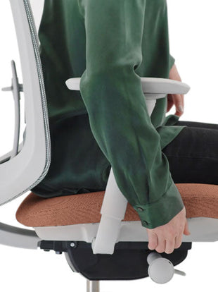 Sidovy av en rosa och grå Verus-kontorsstol från Herman Miller, som visar den justerbara sittdjupet.