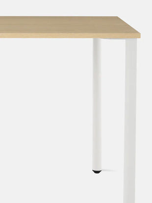 Närbild framifrån av ett vitt och askfärgat OE1-skrivbord från Herman Miller, som visar den hållbara och lättrengjorda bordsskivan.
