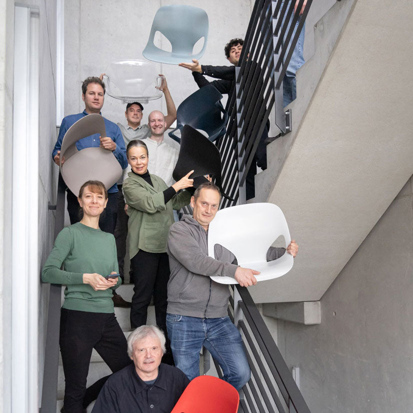 Foto av medlemmarna i designteamet Studio 7.5 i ett trapphus, några av dem håller i olika delar av stolen Herman Zeph som de har designat.